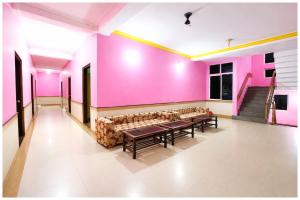 ein Zimmer mit Sofa und rosa Wänden in der Unterkunft Chakra Tirtha Road Hotel Premium D2 Stay Near Sea Beach - WiFi # Parking And Restaurant Facilities- Budget Hotel In Puri in Puri