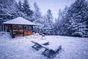 een prieel en een picknicktafel in de sneeuw bij Biały Domek Świerczek in Słopnice