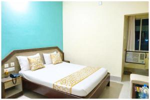 Bett in einem Zimmer mit blauer Wand in der Unterkunft Chakra Tirtha Road Hotel Premium D2 Stay Near Sea Beach - WiFi # Parking And Restaurant Facilities- Budget Hotel In Puri in Puri