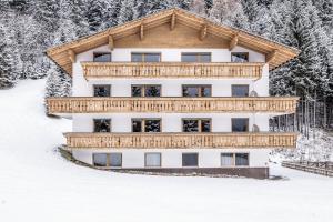 a building in the snow with snow covered trees at Benglerwald Lodge in Bach