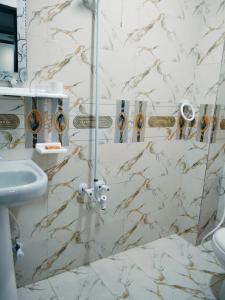 ein Badezimmer mit Dusche und Waschbecken in der Unterkunft Hotel Prime Residency in Karatschi