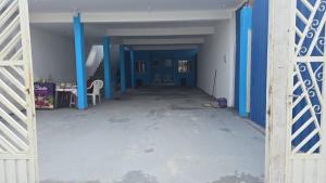 an empty hallway with blue walls and a blue gate at Cantinho dos netos-suites próximo ao Sesc em Bertioga in Bertioga