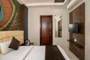 ein Hotelzimmer mit Bett und Fernseher in der Unterkunft Namaste Khatu Shyam in Khātu