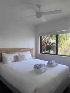 ein Schlafzimmer mit einem großen weißen Bett mit Handtüchern darauf in der Unterkunft Endless Summer 2BR Apartment with Private Beach in Noosa Heads + 25 Fotos