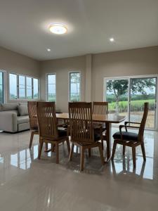 a dining room with a table and chairs and a couch at บ้านไร่สกายดาว in Pak Chong
