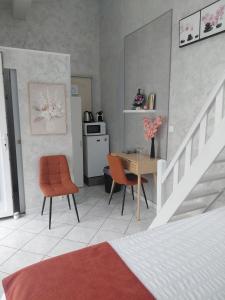 a bedroom with a bed and a table and chairs at Chambres d'hôtes - Les Orchidées in Perpignan