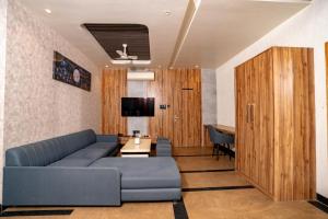 ein Wohnzimmer mit einer blauen Couch und einem Fernseher in der Unterkunft Namaste Khatu Shyam in Khātu