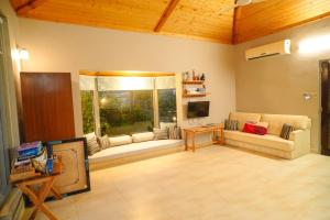 un soggiorno con due divani e una televisione di The River Trail Cottage by The StayCationer a Rājpur