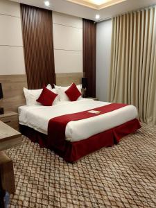 ein Schlafzimmer mit einem großen Bett mit roten Kissen in der Unterkunft راحتي هنا 7 in Riad