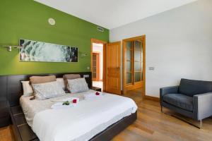 a bedroom with a large bed and a chair at Villas Mamma Mia pool heat Private & Jacuzzi in Playa Blanca