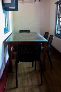 a table with two chairs and a glass top at River view cottage in Vythiri