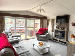 a living room with two couches and a tv at Chloe Cabin in West Thirston