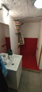 a bathroom with a sink and a red wall at Studio La Cheneraie in Bargemon +9 photos
