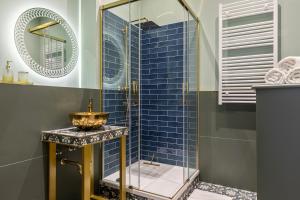 a bathroom with a blue tiled shower with a sink at FABEL Apartments am Hbf in Berlin +85 photos