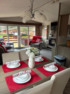 a dining room table with red napkins and plates on it at Chloe Cabin in West Thirston