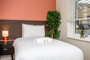 a bedroom with a white bed and a window at Vacant Nests The Allendale Central 3BR in Allendale Town