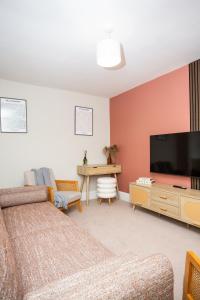 a living room with a couch and a flat screen tv at Vacant Nests The Allendale Central 3BR in Allendale Town