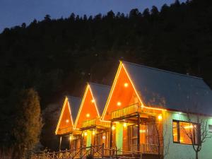 a house with lights on the roof at night at A-Frame Cabins in Sainj