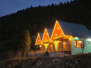 a house lit up at night with lights at A-Frame Cabins in Sainj
