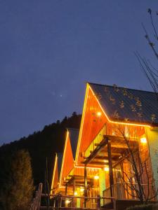 a large building with lights on it at night at A-Frame Cabins in Sainj
