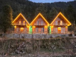 a log home with lights on the front of it at A-Frame Cabins in Sainj