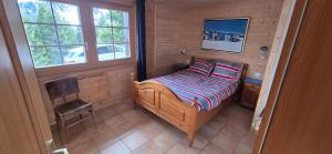 een kleine slaapkamer met een bed en een stoel bij Tuschinski in Les Crosets