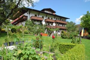 una casa con un jardín delante de ella en Pension Kirchbrugger, en Telfes im Stubai