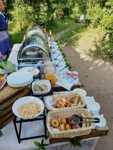 een lange tafel gevuld met borden en kommen van voedsel bij Humble Resort in Masai Mara