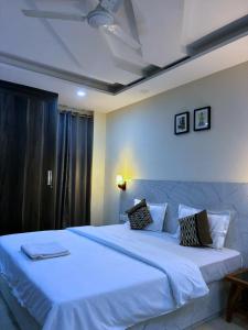 a bedroom with a large bed with white sheets at Cassava Stay - Near Rajendra Place & BLK Hospital in New Delhi +28 photos