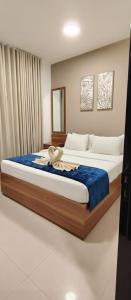 een slaapkamer met een groot bed met een blauwe deken bij Al Khaleej Plaza Furnished Hotel Apartments in Ajman 