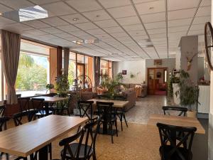 a restaurant with tables and chairs and a couch at Logis Hôtels La Crémaillère in Saint-Bonnet-en-Champsaur