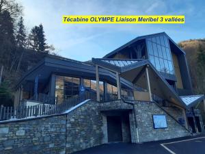 un grand bâtiment avec un balcon au-dessus dans l'établissement MAISON DES VIGNES- TROQUAÏROU et BECCA MOTTA, à Brides-les-Bains