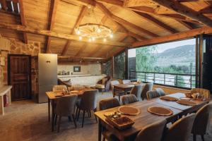 een eetkamer met tafels en stoelen en een groot raam bij Hatun Konağı in Eskiömerler
