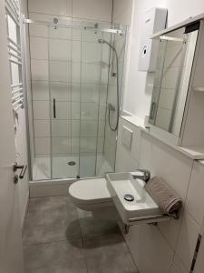 een witte badkamer met douche en wastafel bij Apartment 1 in Stockach