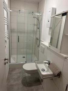 een badkamer met een douche, een toilet en een wastafel bij Apartment 1 in Stockach +3 foto's