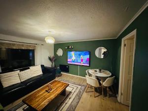 a living room with a couch and a table at 3 bedroom apartment in Cumbernauld