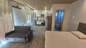 VideiraApartamento Loft Terreo的一间带床和椅子的房间和一间厨房