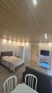 VideiraApartamento Loft Terreo的一间卧室，里面有一张床、一张桌子和几把椅子。 更多2张照片