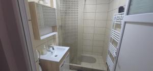 ein weißes Badezimmer mit Waschbecken und Dusche in der Unterkunft Apartament Central in Câmpina