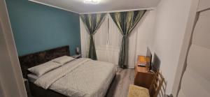 a small bedroom with a bed and a window at Apartament Central in Câmpina