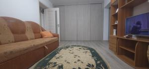 ein Wohnzimmer mit Sofa und Fernseher in der Unterkunft Apartament Central in Câmpina