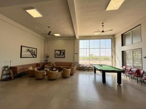 ein Wohnzimmer mit einer Tischtennisplatte und Stühlen in der Unterkunft Oasis Residency and Resorts in Solapur