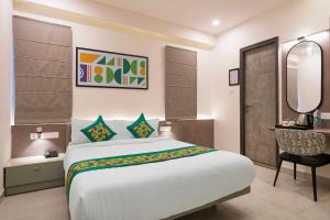 een slaapkamer met een groot bed en een spiegel bij Treebo Premium Hydotel Gachibowli in Hyderabad