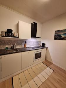 eine Küche mit weißen Schränken und einer Spüle in der Unterkunft Apartment 3 Sea Centrum Stavanger in Stavanger