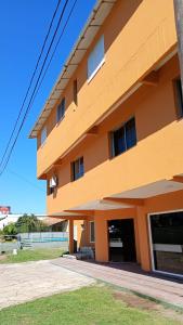 ein orangefarbenes Gebäude mit Fenstern an der Seite in der Unterkunft KIN Hotel in Villa Carlos Paz