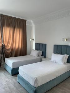 zwei nebeneinander stehende Betten in einem Schlafzimmer in der Unterkunft Crystal in Tangier