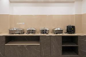 een toonbank met vier broodroosterschalen erop bij Treebo Premium Hydotel Gachibowli in Hyderabad