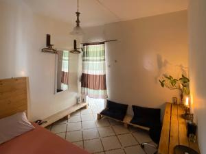 ein Schlafzimmer mit einem Bett und einem Tisch und einem Fenster in der Unterkunft Villa Éden in Dakar