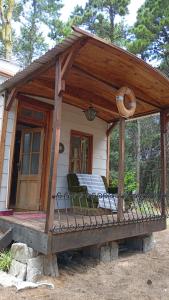 a gazebo with chairs sitting on a porch at La tinyhouse del bosque in Mar Azul +24 photos