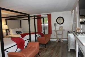 een slaapkamer met een hemelbed en een stoel bij Scenic Vista Inn in North Conway